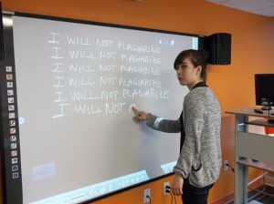 EC Academic Assistant Renee 'doing lines' on the board in a style borrowed from The Simpsons' theme song animation.